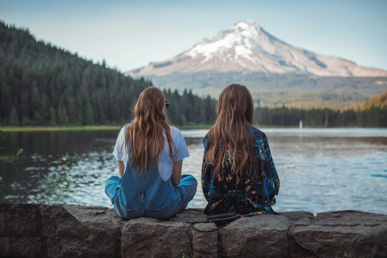abortion legality in colorado - two girls sit in front of a mountain