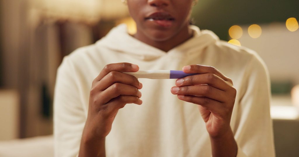 young woman looking unsure about pregnancy test results