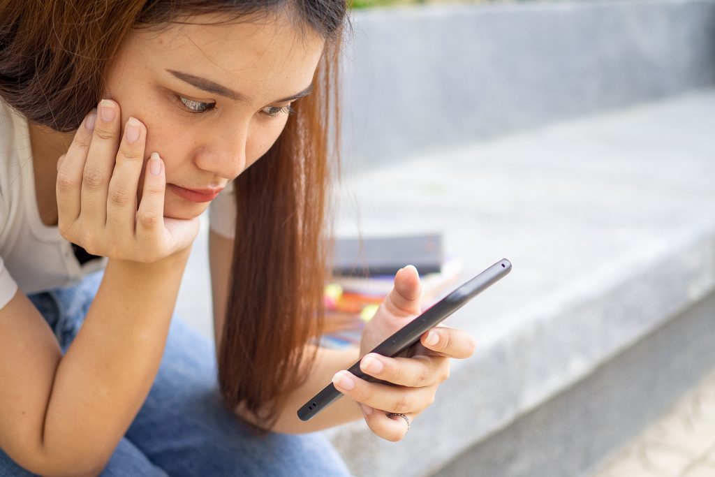 una mujer busca en su teléfono los riesgos del aborto farmacológico
